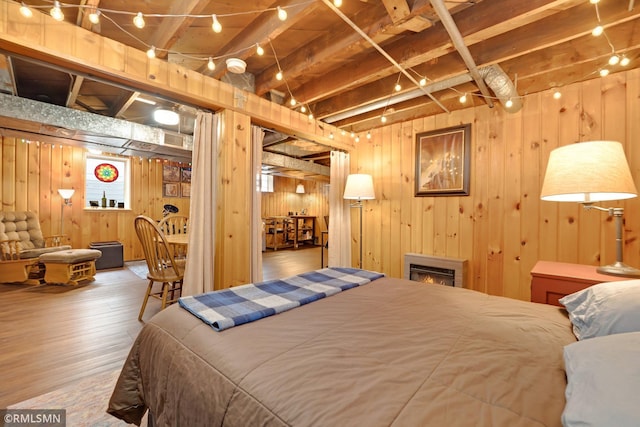 5116 28th Ave S, Minneapolis, MN 55417 - bedroom featuring hardwood / wood-style flooring, wooden walls, and a lit fireplace