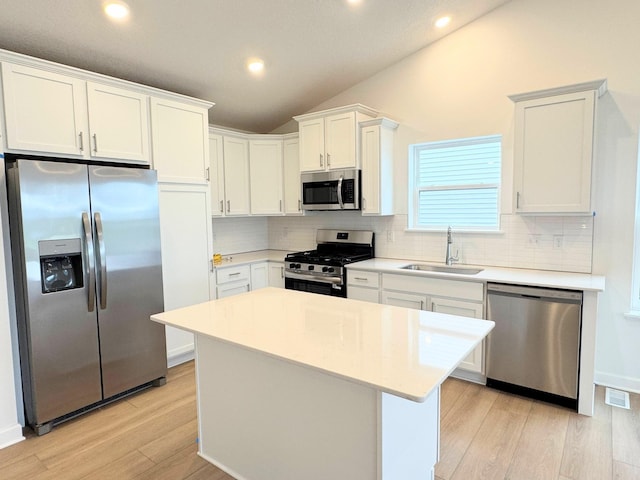 7031 Lannon Ave NE, Otsego, MN 55301 - kitchen with appliances with stainless steel finishes, lofted ceiling, decorative backsplash, light wood finished floors, and light countertops