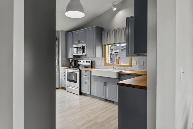 920 Lincoln Ct S, Cambridge, MN 55008 - kitchen featuring appliances with stainless steel finishes, butcher block counters, gray cabinets, tasteful backsplash, and a textured ceiling