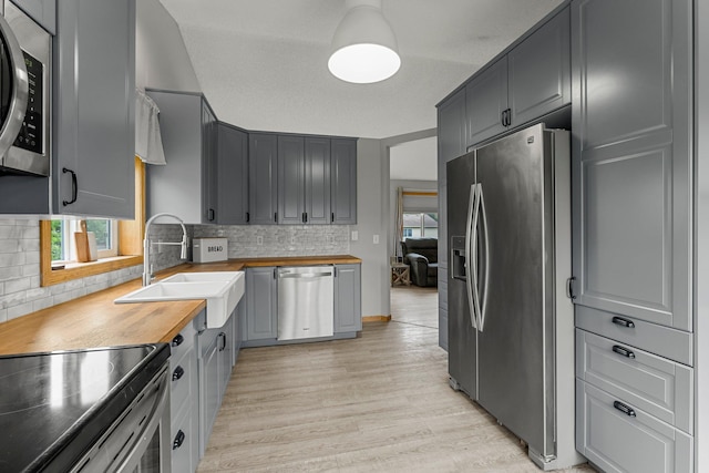 920 Lincoln Ct S, Cambridge, MN 55008 - kitchen with appliances with stainless steel finishes, butcher block counters, light wood-style flooring, and decorative backsplash