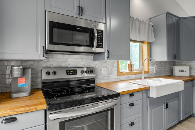 920 Lincoln Ct S, Cambridge, MN 55008 - kitchen with wood counters, appliances with stainless steel finishes, tasteful backsplash, and gray cabinets