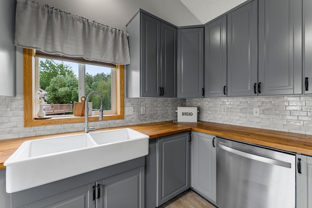 920 Lincoln Ct S, Cambridge, MN 55008 - kitchen with stainless steel dishwasher, butcher block countertops, gray cabinets, tasteful backsplash, and vaulted ceiling