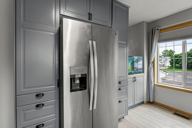 920 Lincoln Ct S, Cambridge, MN 55008 - kitchen featuring stainless steel refrigerator with ice dispenser, gray cabinetry, light wood-style flooring, and a textured ceiling