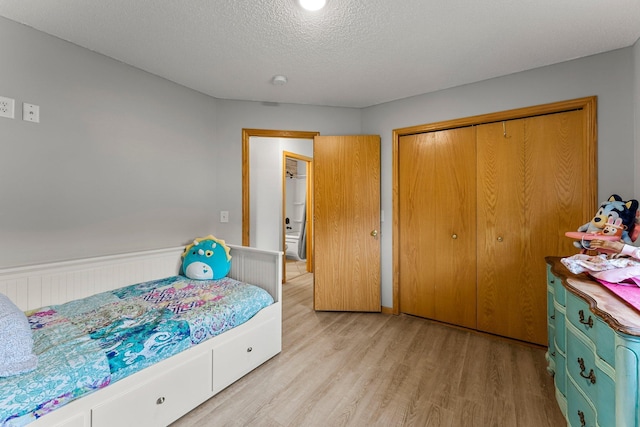 920 Lincoln Ct S, Cambridge, MN 55008 - bedroom with light wood-style floors, a closet, a wainscoted wall, and a textured ceiling