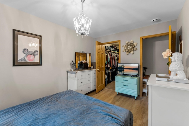 920 Lincoln Ct S, Cambridge, MN 55008 - bedroom with light wood finished floors, a chandelier, a walk in closet, and a closet