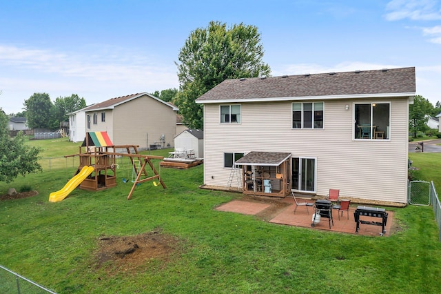 920 Lincoln Ct S, Cambridge, MN 55008 - back of property with a patio area, a fenced backyard, a storage unit, a playground, and roof with shingles