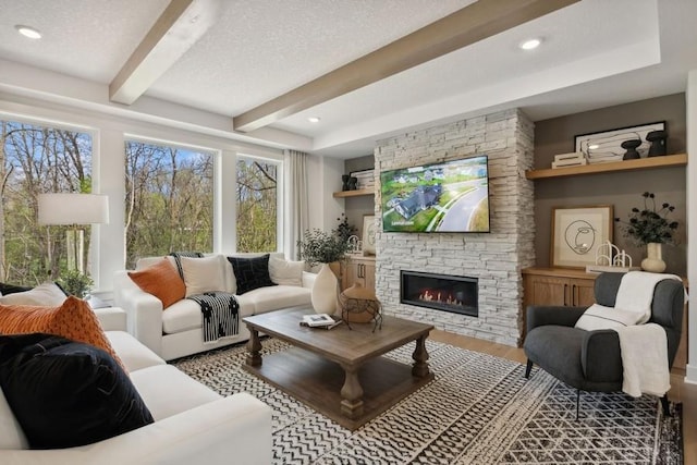 20090 63rd Ave, Corcoran, MN 55340 - living room featuring beamed ceiling, wood finished floors, a stone fireplace, and a textured ceiling