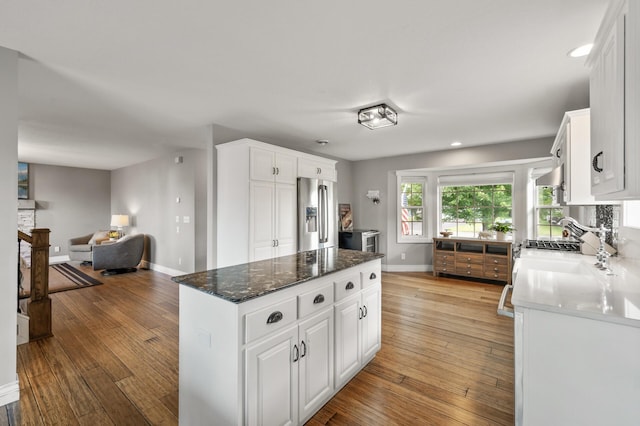 12864 Fondant Trl N, Hugo, MN 55038 - kitchen featuring stainless steel fridge with ice dispenser, light wood-type flooring, white cabinetry, a center island, and open floor plan