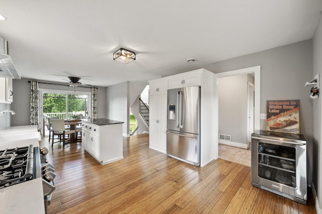 12864 Fondant Trl N, Hugo, MN 55038 - kitchen with stainless steel fridge, ceiling fan, beverage cooler, range, and white cabinets