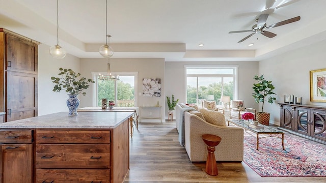509 Golfview Ave, Zumbrota, MN 55992 - living area with a raised ceiling, light wood-style flooring, a ceiling fan, recessed lighting, and a chandelier