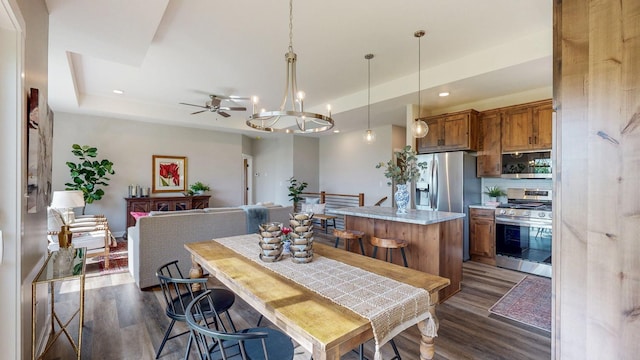 509 Golfview Ave, Zumbrota, MN 55992 - dining space with dark wood finished floors, recessed lighting, a tray ceiling, a ceiling fan, and a chandelier