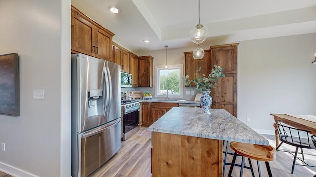 509 Golfview Ave, Zumbrota, MN 55992 - kitchen with appliances with stainless steel finishes, light wood-style floors, a kitchen island, a kitchen bar, and brown cabinets