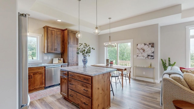 509 Golfview Ave, Zumbrota, MN 55992 - kitchen featuring stainless steel dishwasher, a tray ceiling, light wood finished floors, open floor plan, and backsplash