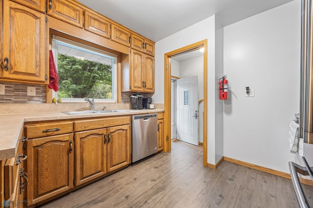 1917 7th St S, Moorhead, MN 56560 - kitchen featuring stainless steel dishwasher, light countertops, tasteful backsplash, and light wood-style flooring