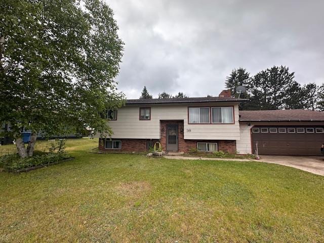 38 Locust Dr, Babbitt, MN 55706 - bi-level home featuring a garage, concrete driveway, a front lawn, and a chimney