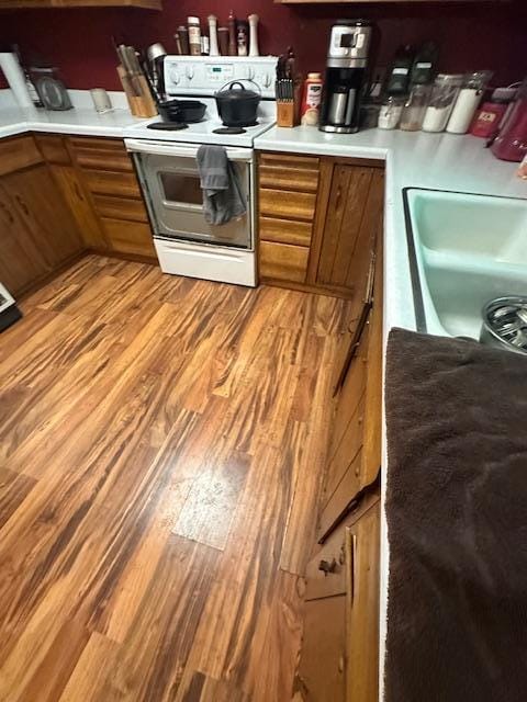 38 Locust Dr, Babbitt, MN 55706 - kitchen with electric range, brown cabinets, light wood finished floors, and light countertops
