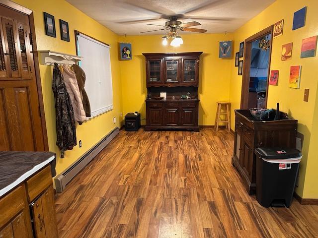 38 Locust Dr, Babbitt, MN 55706 - dining room with a baseboard radiator, ceiling fan, dark wood-style floors, and baseboards
