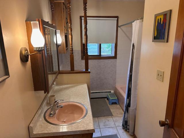 38 Locust Dr, Babbitt, MN 55706 - full bathroom with vanity, a baseboard heating unit, tile patterned flooring, and shower / bath combination with curtain