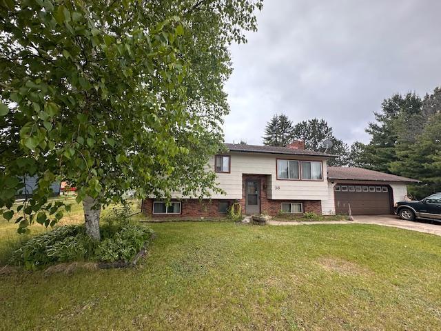 38 Locust Dr, Babbitt, MN 55706 - bi-level home featuring a front yard, driveway, a chimney, and a garage