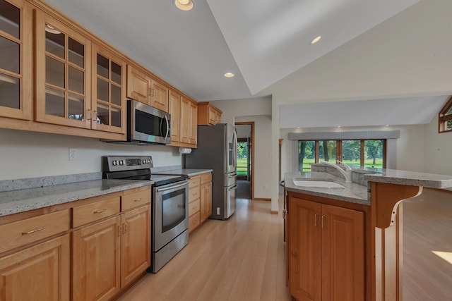 332 Waite Ave S, Saint Cloud, MN 56301 - kitchen with appliances with stainless steel finishes, light stone countertops, light wood-style flooring, a kitchen breakfast bar, and lofted ceiling