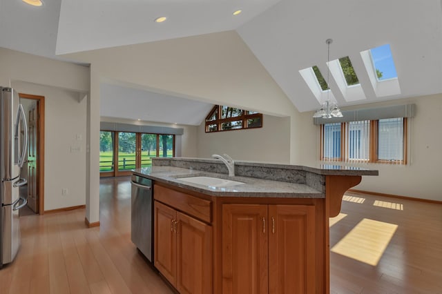 332 Waite Ave S, Saint Cloud, MN 56301 - kitchen with a skylight, appliances with stainless steel finishes, lofted ceiling, light wood finished floors, and light stone countertops