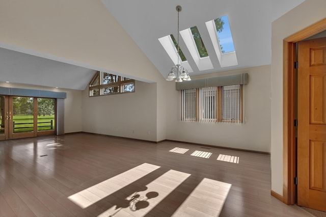 332 Waite Ave S, Saint Cloud, MN 56301 - unfurnished living room featuring high vaulted ceiling, a skylight, wood finished floors, and a chandelier