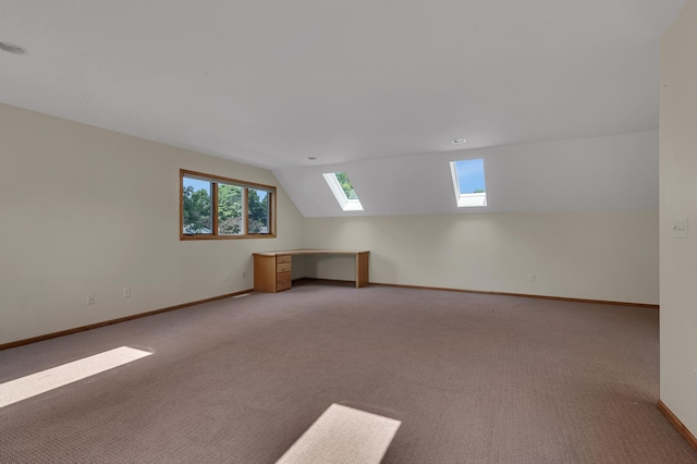 332 Waite Ave S, Saint Cloud, MN 56301 - empty room featuring a skylight, vaulted ceiling, carpet flooring, and an office area