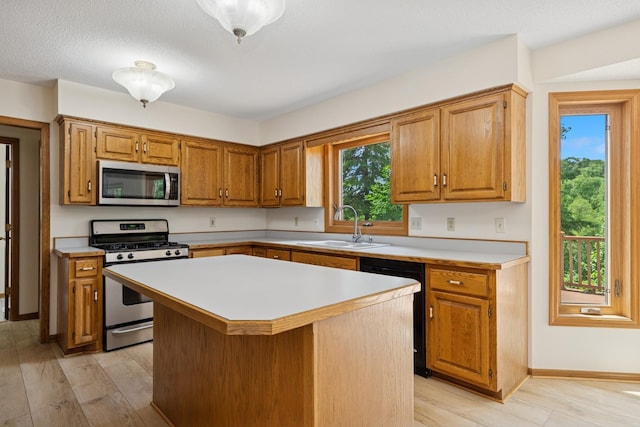 6233 Fernbrook Ln N, Maple Grove, MN 55311 - kitchen with stainless steel appliances, light countertops, a center island, light wood-type flooring, and brown cabinets