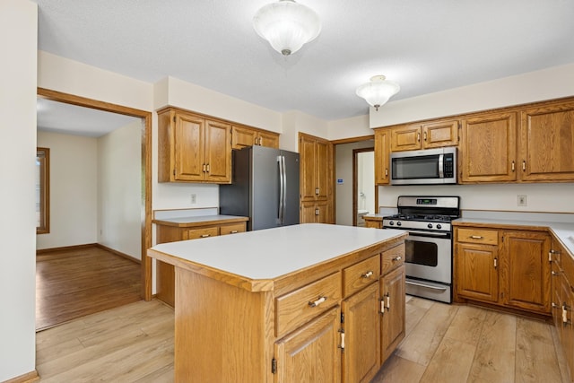 6233 Fernbrook Ln N, Maple Grove, MN 55311 - kitchen with appliances with stainless steel finishes, light wood-type flooring, light countertops, and a center island