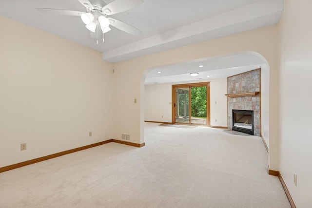 6233 Fernbrook Ln N, Maple Grove, MN 55311 - unfurnished living room with arched walkways, a tile fireplace, carpet floors, and ceiling fan