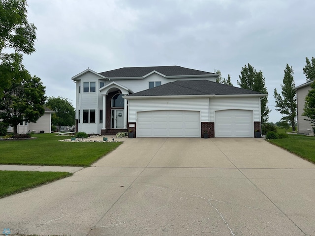 3110 46th Ave S, Fargo, ND 58104 - traditional-style house with an attached garage, concrete driveway, brick siding, a front yard, and a shingled roof