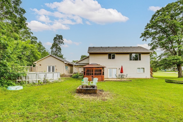 3220 Vine St, Cambridge, MN 55008 - back of property featuring an outdoor pool, a sunroom, a yard, and an outdoor fire pit