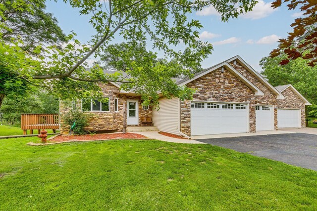 3220 Vine St, Cambridge, MN 55008 - view of front of house featuring a garage, asphalt driveway, stone siding, and a front yard