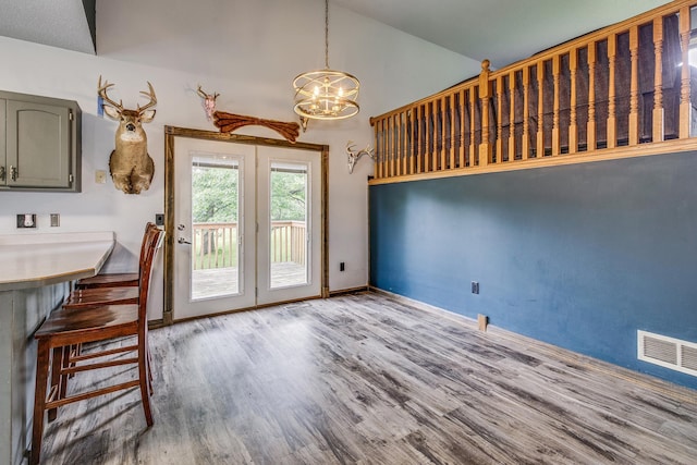 3220 Vine St, Cambridge, MN 55008 - unfurnished dining area with a chandelier, wood finished floors, french doors, and high vaulted ceiling