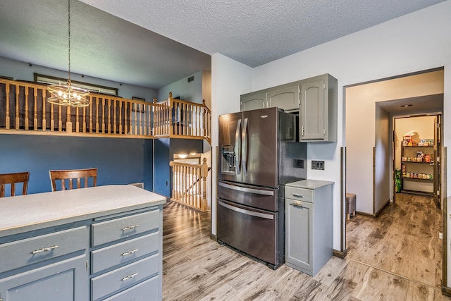3220 Vine St, Cambridge, MN 55008 - kitchen featuring stainless steel refrigerator with ice dispenser, gray cabinetry, light wood-style floors, a chandelier, and light countertops