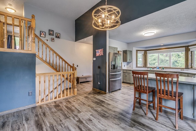 3220 Vine St, Cambridge, MN 55008 - kitchen with stainless steel fridge, wood finished floors, a chandelier, light countertops, and gray cabinets