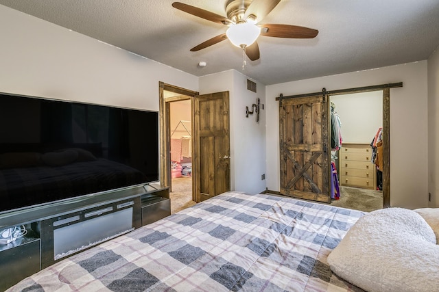 3220 Vine St, Cambridge, MN 55008 - carpeted bedroom featuring a barn door, a spacious closet, a closet, and a ceiling fan