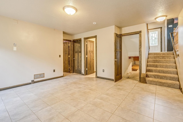 3220 Vine St, Cambridge, MN 55008 - spare room with a textured ceiling, stairs, and light tile patterned flooring