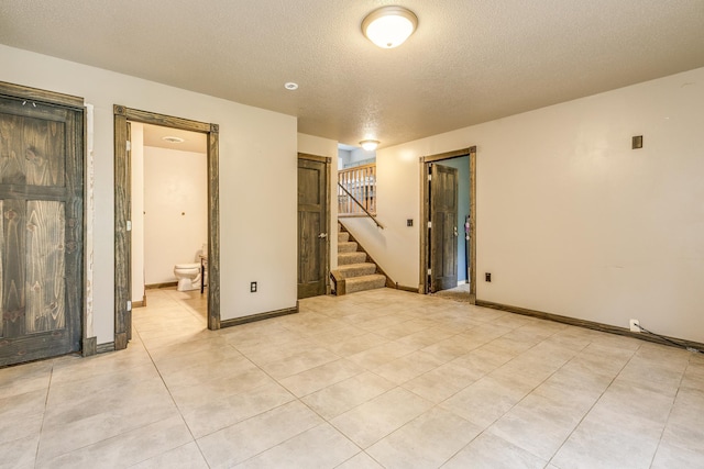3220 Vine St, Cambridge, MN 55008 - empty room with a textured ceiling, stairs, and light tile patterned floors