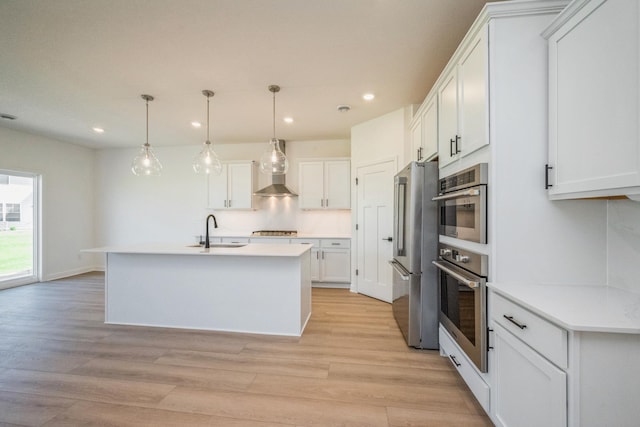 14526 111th Ave E, Dayton, MN 55369 - kitchen featuring appliances with stainless steel finishes, a sink, wall chimney exhaust hood, recessed lighting, and light wood-style floors