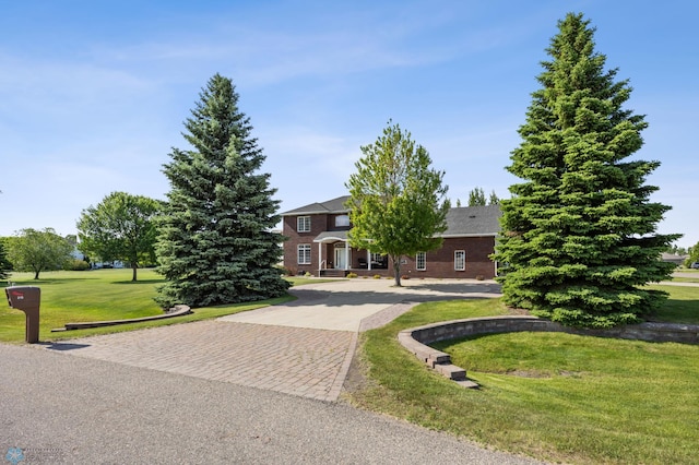 215 51st Ave E, West Fargo, ND 58078 - obstructed view of property featuring decorative driveway, a front lawn, and brick siding