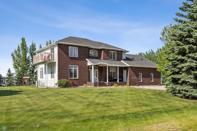 215 51st Ave E, West Fargo, ND 58078 - view of front of property featuring a balcony, brick siding, a front yard, and covered porch