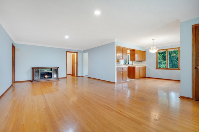 895 Humboldt Ave W, Saint Paul, MN 55118 - unfurnished living room featuring a chandelier, light wood-type flooring, a warm lit fireplace, and recessed lighting
