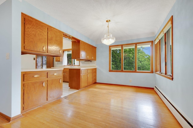 895 Humboldt Ave W, Saint Paul, MN 55118 - kitchen with baseboard heating, light wood-type flooring, a chandelier, and plenty of natural light