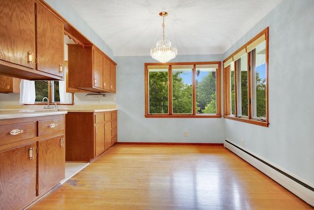 895 Humboldt Ave W, Saint Paul, MN 55118 - kitchen featuring a baseboard heating unit, brown cabinetry, light wood-type flooring, and light countertops