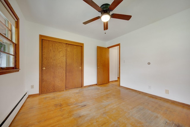 895 Humboldt Ave W, Saint Paul, MN 55118 - unfurnished bedroom featuring a baseboard radiator, light wood-style floors, a closet, and a ceiling fan