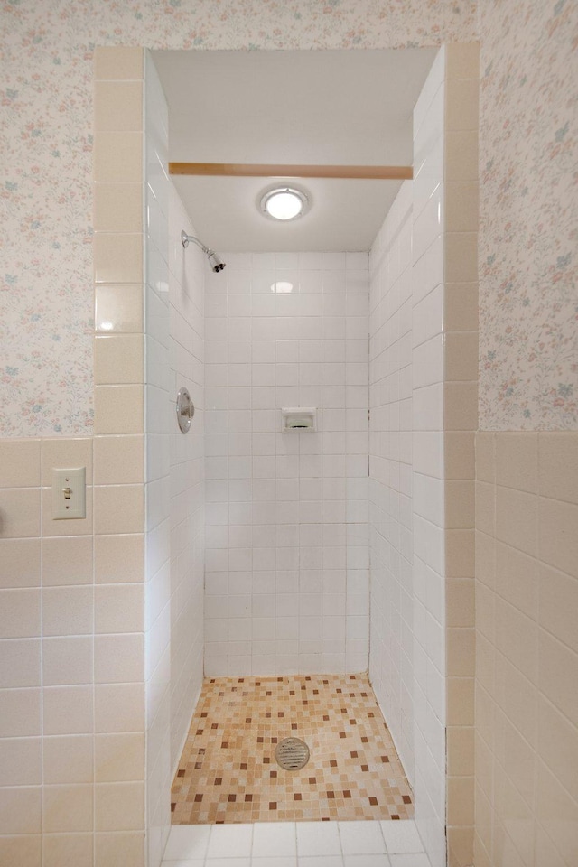 895 Humboldt Ave W, Saint Paul, MN 55118 - bathroom with wallpapered walls, tiled shower, and a wainscoted wall