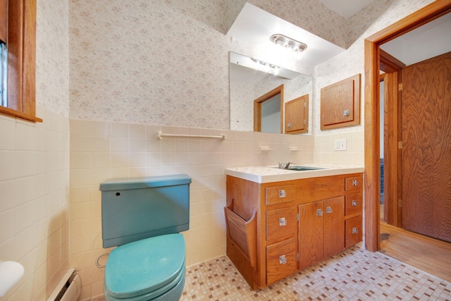 895 Humboldt Ave W, Saint Paul, MN 55118 - bathroom with tile walls, wallpapered walls, vanity, baseboard heating, and wainscoting