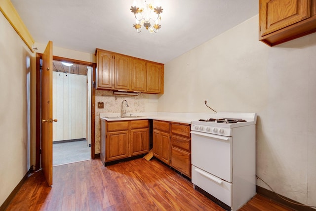 895 Humboldt Ave W, Saint Paul, MN 55118 - kitchen featuring white range with gas stovetop, light countertops, dark wood-style flooring, decorative backsplash, and brown cabinets