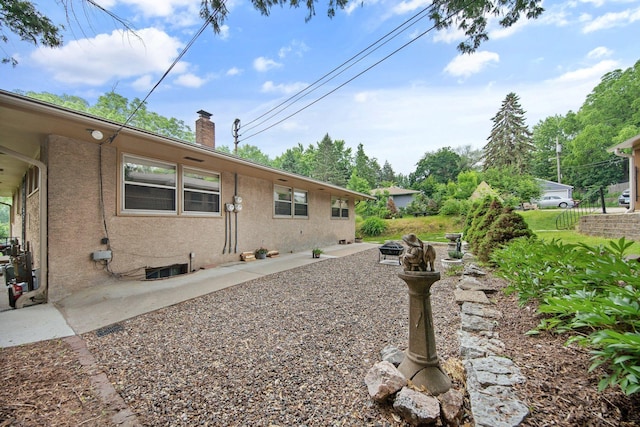895 Humboldt Ave W, Saint Paul, MN 55118 - view of side of property featuring a chimney, stucco siding, and an outdoor fire pit